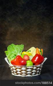fresh vegetables and fruits in wicker basket over wooden background. vegetables and fruits in wicker basket 