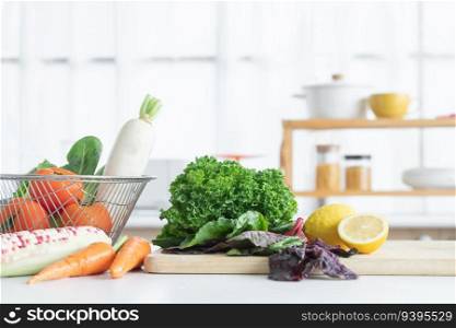 Fresh vegetables and yellow lemon placed on cutting board, tomatoes, white radish, cos salad in basket, carrots, corn on table. Healthy and vegetarian food in home kitchen