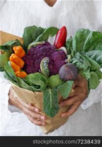 Fresh vegetables decorated in a bouquet. Men?s hands hold fresh vegetables. Harvesting. Close-up.