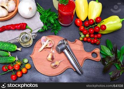Fresh vegetables for preparation of salad and juice on a black wooden background, view of a scaffolding