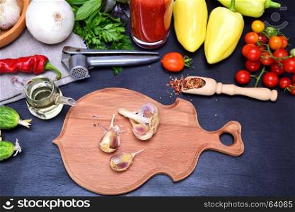 Fresh vegetables for salad and garlic on a black background, top view