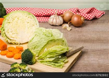 Fresh vegetables from the garden, carrots, cabbage, broccoli, onion and garlic on a wooden table. Vegetables for preparing soup