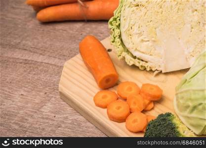 Fresh vegetables from the garden, carrots, cabbage, broccoli, onion and garlic on a wooden table. Vegetables for preparing soup