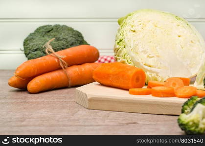 Fresh vegetables from the garden, carrots, cabbage, broccoli, onion and garlic on a wooden table. Vegetables for preparing soup