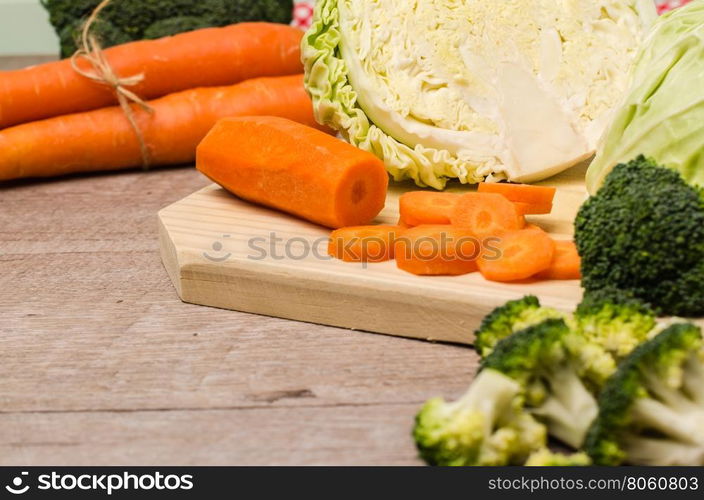 Fresh vegetables from the garden, carrots, cabbage, broccoli, onion and garlic on a wooden table. Vegetables for preparing soup