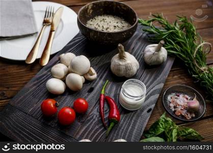Fresh vegetables on board and rice in plate, on wooden background. Organic vegetarian food, grocery assortment, natural products, healthy lifestyle concept. Fresh vegetables on board and rice in plate