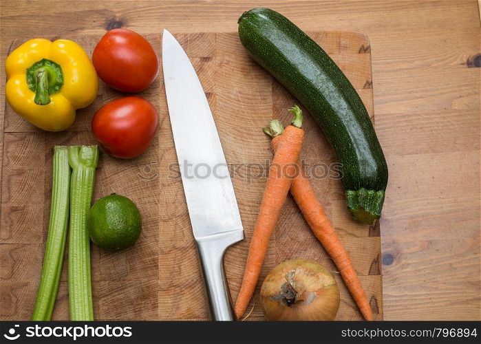 fresh vegetables on the cutting board and knife onion, tomatoes,carrot lemons., paprika, on wood background healthy. fresh vegetables on the cutting board and knife onion, tomatoes,carrot lemons., paprika, on wood background