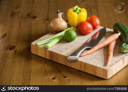 fresh vegetables on the cutting board and knife onion, tomatoes,carrot lemons., paprika, on wood background healthy. fresh vegetables on the cutting board and knife onion, tomatoes,carrot lemons., paprika, on wood background