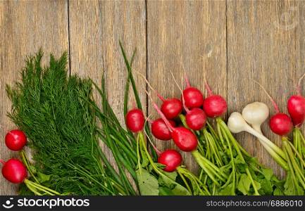 Fresh vegetables on wooden table. Radish, onion, garlic, dill on old wooden background. Top view.