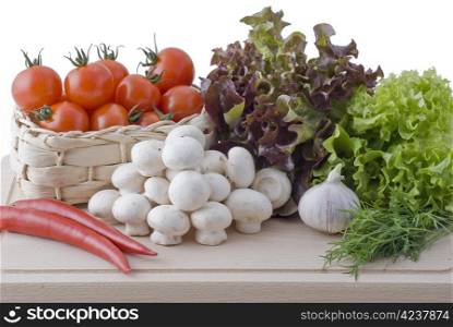 Fresh vegetables - salad, tomatos, red peppers, mushrooms, garlic and dill placed on chopping board