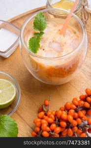 fresh vegetarian fruit smoothie on wooden tray with fresh  bananas, sea buckthorn, lime, melissa and coconut milk . Healthy breakfast. close up