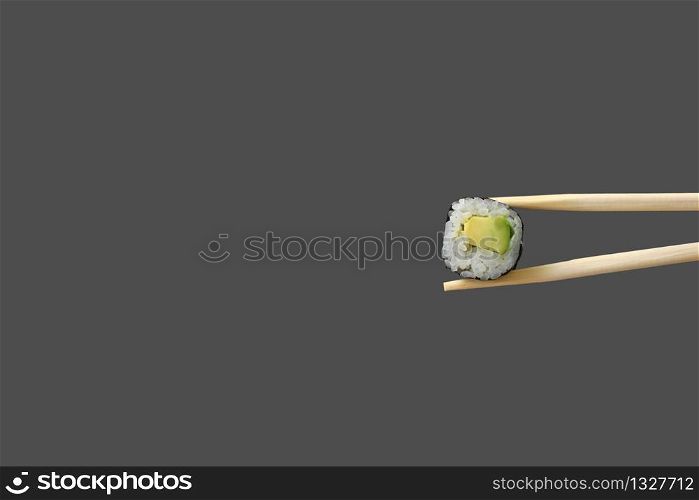 fresh vegetarian maki sushi roll with wooden chopsticks isolated on grey background. copy space.. fresh vegetarian maki sushi roll with wooden chopsticks isolated on grey background. copy space