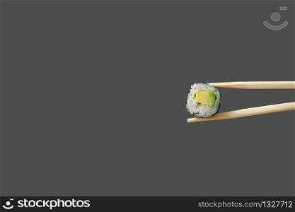 fresh vegetarian maki sushi roll with wooden chopsticks isolated on grey background. copy space.. fresh vegetarian maki sushi roll with wooden chopsticks isolated on grey background. copy space