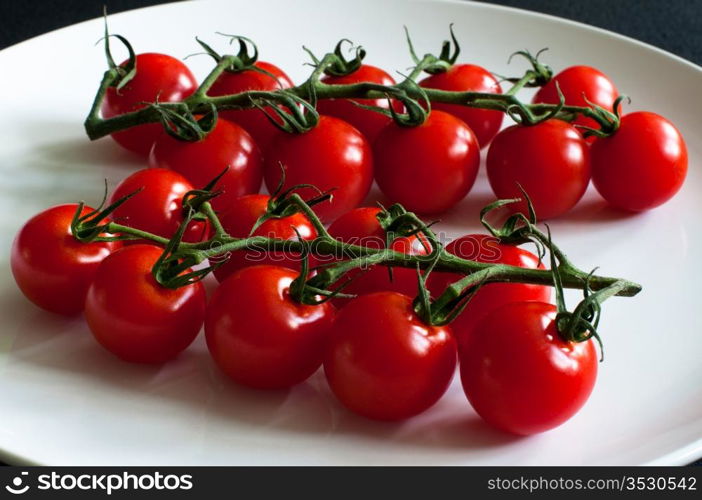 Fresh vine tomatoes / cherry tomatoes on white plate