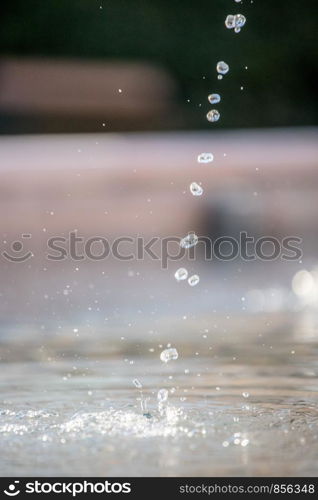 Fresh water drops falling into a well, summer time