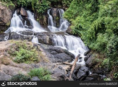 Fresh waterfall from the granite cliff in rainforest of the Thai national park.