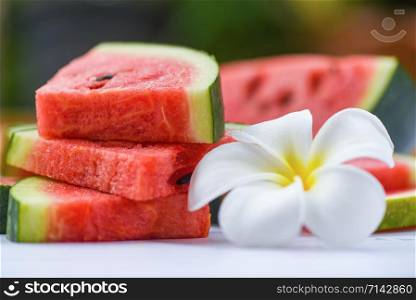 Fresh watermelon slice and white flower / watermelon tropical fruit on nature background , selective focus