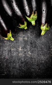 Fresh wet eggplant on the table. On a black background. High quality photo. Fresh wet eggplant on the table. 