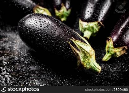 Fresh wet eggplant on the table. On a black background. High quality photo. Fresh wet eggplant on the table. 