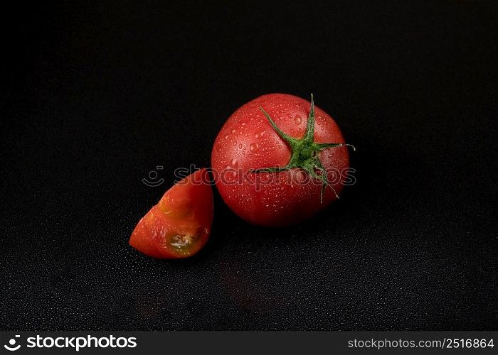 fresh wet tomatoes on a black background. sliced tomatoes. tomatoes on a black background