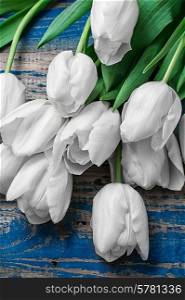 fresh white tulips on a background of old wood
