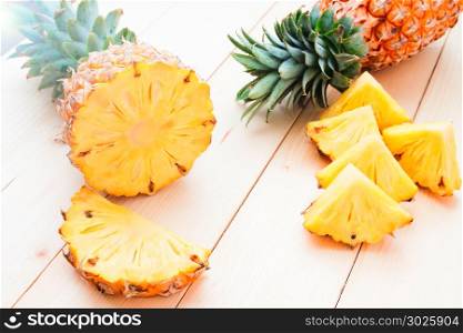 Fresh whole and cut pineapple on wooden table, Tropical fruit