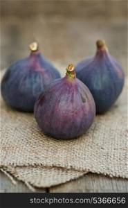 Fresh whole figs on wooden and hessian background