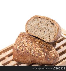 Fresh whole grain bread on cutting board cut in half over white background