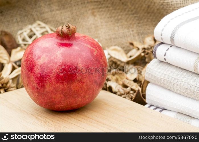 Fresh whole pomegranite on rustic wooden setting. Macro image of fresh whole pomegranite