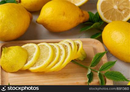 fresh whole yellow lemons and sliced fruits, ingredients for making summer drinks, top view