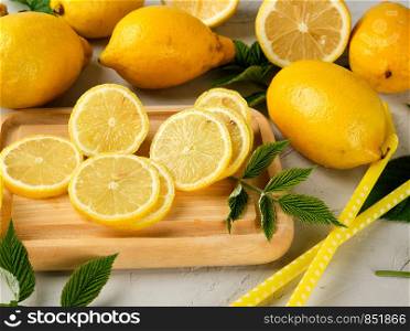 fresh whole yellow lemons and sliced fruits, ingredients for making summer drinks, top view