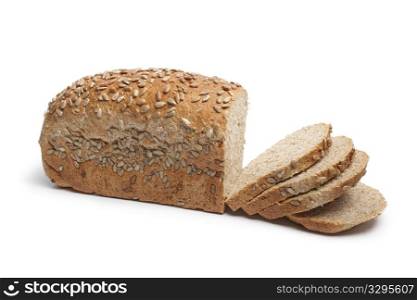 Fresh wholewheat bread with sunflower seeds and slices on white background