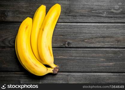 Fresh yellow bananas. On a black wooden background.. Fresh yellow bananas.
