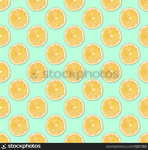 Fresh yellow lemon slices seamless pattern. Close up of citrus fruit slices on pastel blue background. Studio photography.. Background of fresh yellow lemon slices. Seamless pattern. Close up. Studio photography.