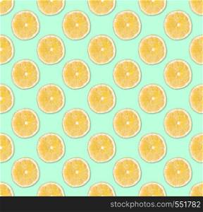 Fresh yellow lemon slices seamless pattern. Close up of citrus fruit slices on pastel blue background. Studio photography.. Background of fresh yellow lemon slices. Seamless pattern. Close up. Studio photography.