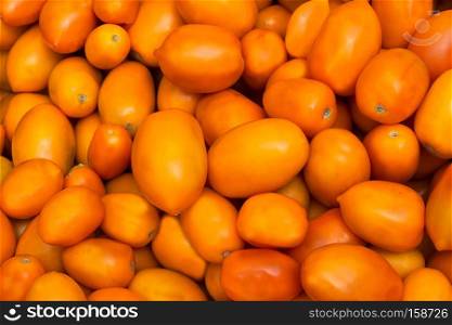 Fresh yellow orange tomato background as abundance harvest symbol. Healthy lifestyle concept with ripe vegetables 