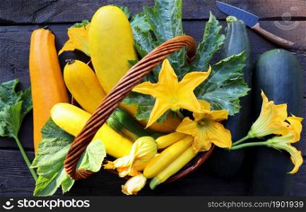 Fresh zucchini in a basket. Zucchini with flowers on the old rustic wooden table .. Fresh zucchini in a basket. Zucchini with flowers on the old rustic wooden table