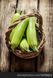 Fresh zucchini in the basket. On wooden background.. Fresh zucchini in the basket.