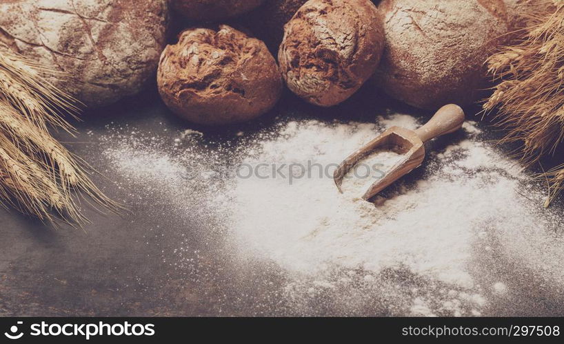 Freshly baked bread and flour in a bakery concept set dark moody