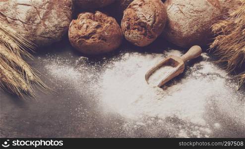 Freshly baked bread and flour in a bakery concept set dark moody