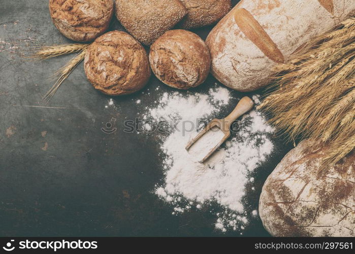 Freshly baked bread and flour in a bakery concept set dark moody