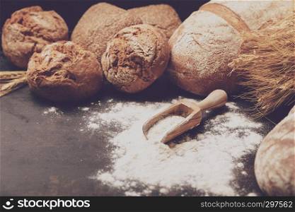 Freshly baked bread and flour in a bakery concept set dark moody