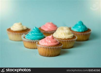 Freshly baked colorful cupcakes on blue background