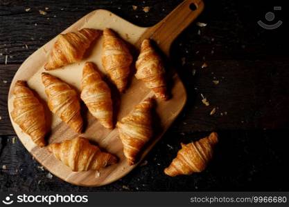 freshly baked croissants on wooden cutting board