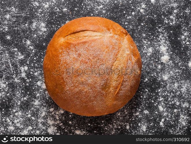 Freshly baked gluten free organic bread with flour on black background