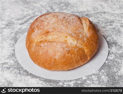 Freshly baked gluten free organic bread with flour on grey background