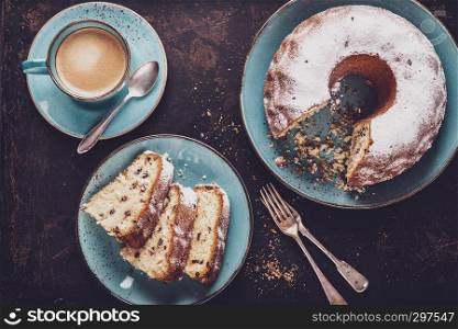 freshly baked gugelhupf with a cup of coffee crema on a dark background, top view