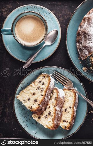 freshly baked gugelhupf with a cup of coffee crema on a dark background, top view