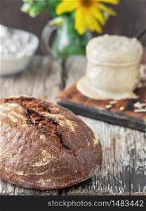 Freshly baked homemade bread, closeup. The concept of a healthy diet made from natural products, traditional craft bread cooked with natural sourdough. Sourdough and flour in the background