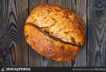 Freshly baked homemade tartine bread on dark wooden table